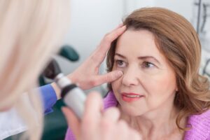 Doctor examining a patient’s eyes for cataracts during a laser cataract surgery consultation.